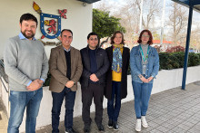 5 personas posan frente al ingreso principal de la Casa Central