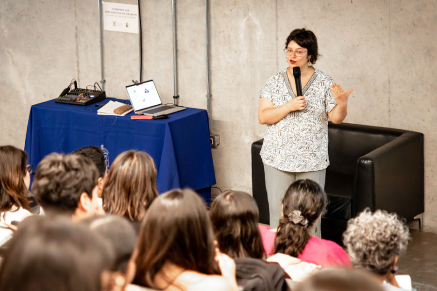 Mujer expone ante personas que se ven de espaldas en la imagen