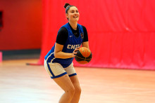 Estudiante jugadora de básquetbol en posición de tirar al aro