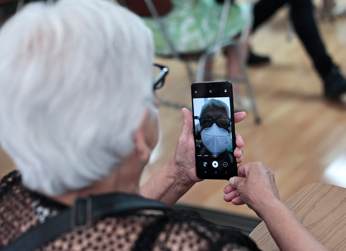 Mujer de la tercera edad revisando una app en su celular.