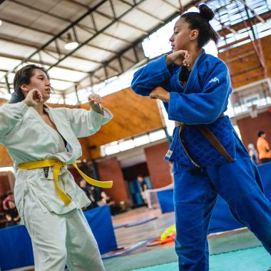 Dos jóvenes practicando judo. La imagen corta los pies de las chicas y está ladeada hacia el lado izquierdo.