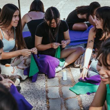 se muestra un grupo de mujeres en el campus preparándo las actividades a realizar en distintos sectores del Campus Universitario