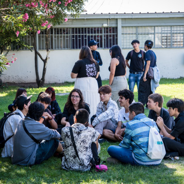 Estudiantes sentados en el pasto