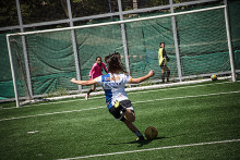 Jugadora de fútbol patea balón al arco 