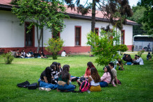 estudiantes sentadas en los pastos del Campus