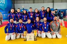 Damas y varones que componen la selección de judo posan en una foto grupal con las copas alcanzadas