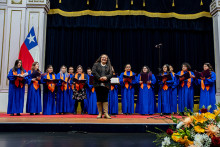 Integrantes del coro estudiantil sobre el escenario del Aula Magna