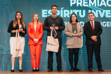 Fondo azul, letras blancas, decano, autoridades y estudiantes premiados