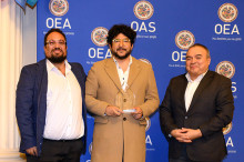 Dr. Pablo Zamora con reconocimiento entremedio de personas de la OEA