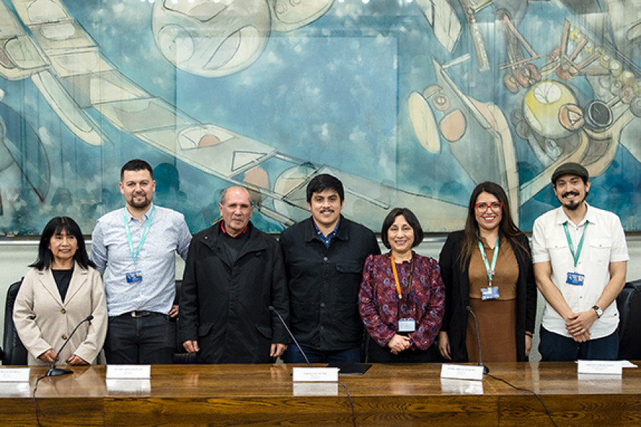 Directiva Asociación de Funcionarias y Funcionarios Usach. De fondo, cuadro de Roberto Matta en el Salón de Honor