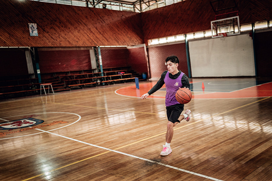 Estudiante jugando básquetbol en gimnasio Usach