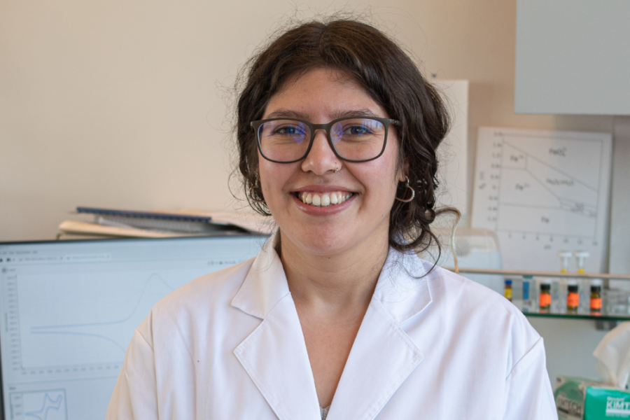 Imagen muestra a investigadora sonriendo frente a la cámara en su laboratorio