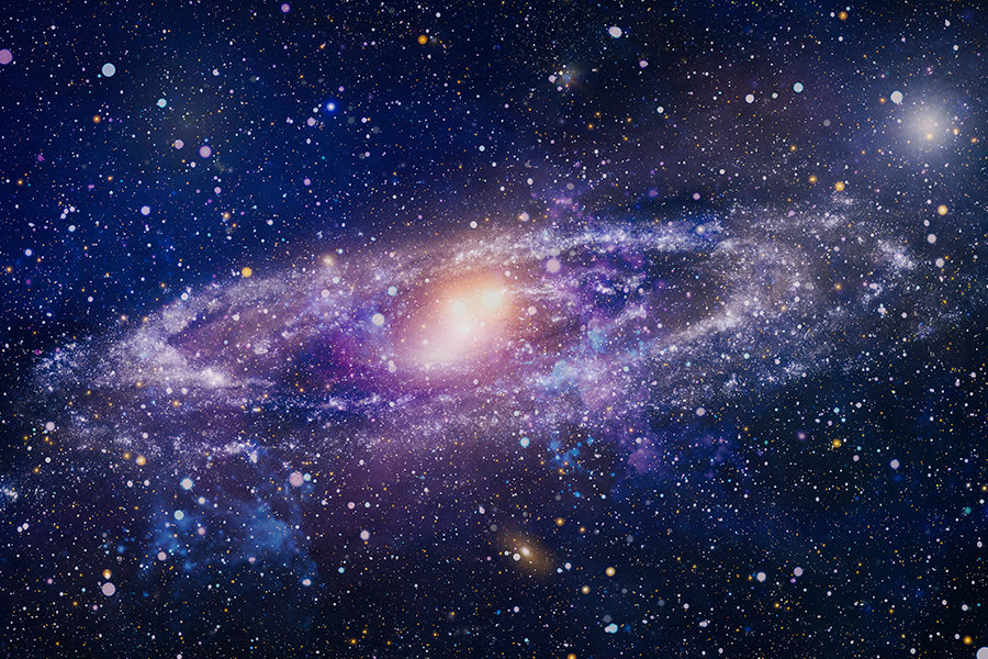 The image depitcts a purple and blue spiral galaxy glowing amidst a vast, star-filled cosmic nebula.