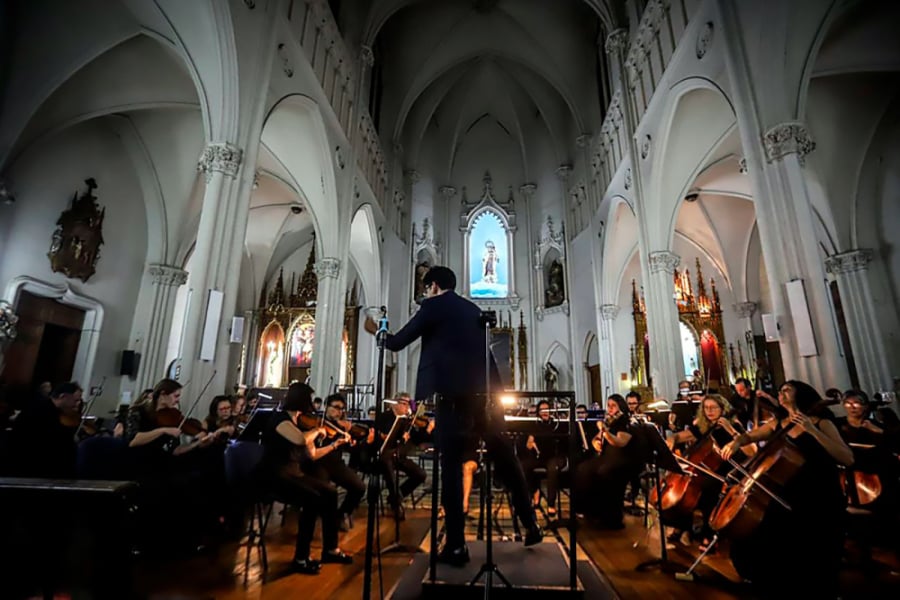 En la imagen se muestra una orquesta tocando en una iglesia 