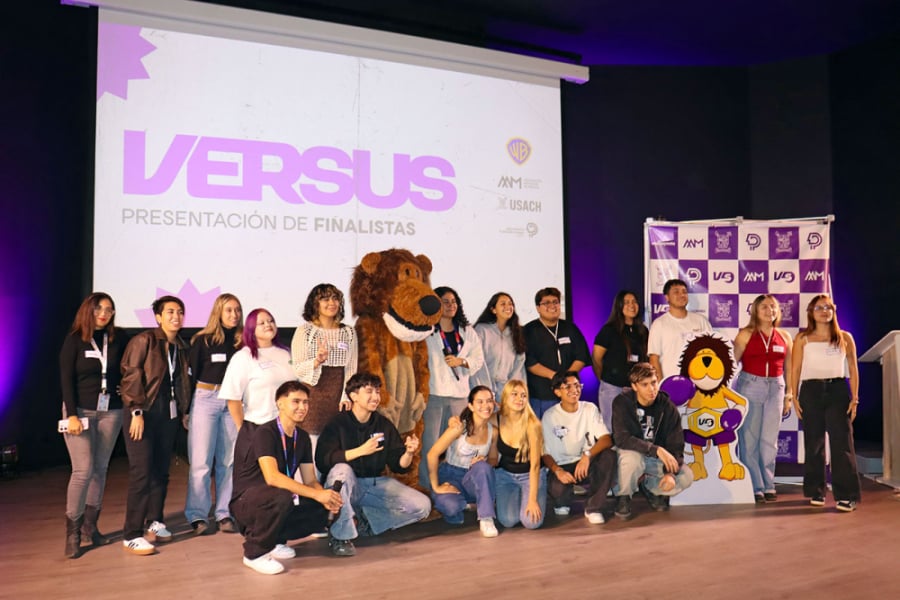En la fotografía aparecen estudiantes que participaron del evento junto a Usachín. De fondo, una pantalla con el logo de Versus.