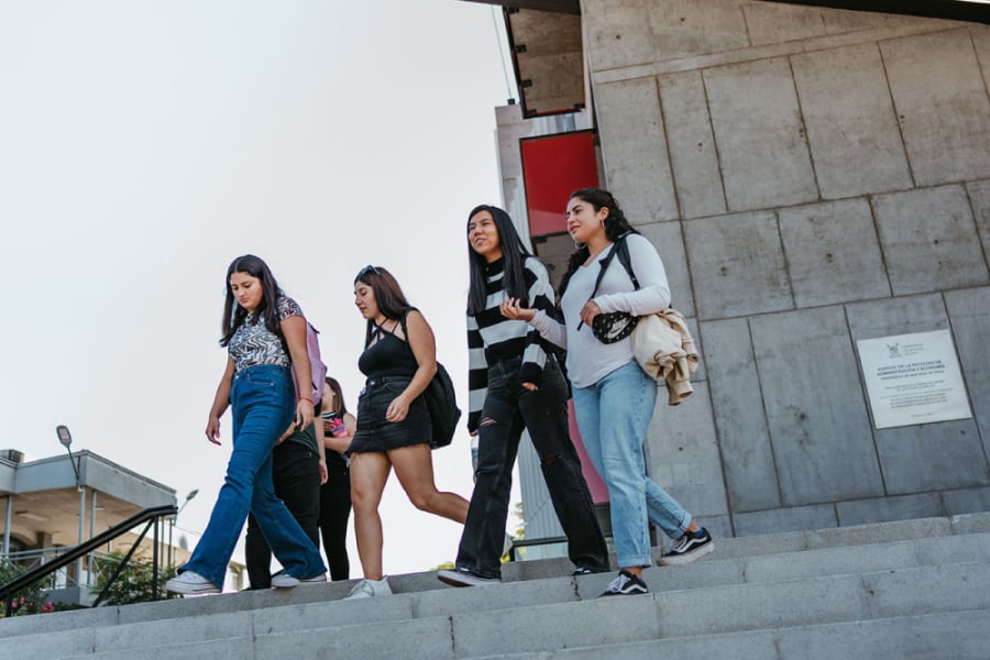 Estudiantes bajan las escaleras en la explanada del edificio FAE