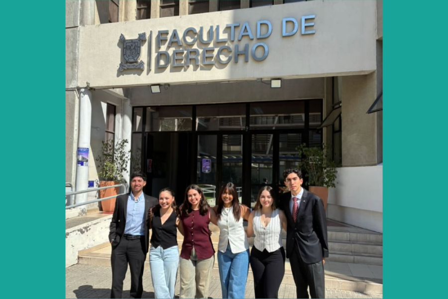 Estudiantes posan en la fachada de la Facultad de Derecho Usach. Son dos hombres y cuatro mujeres.