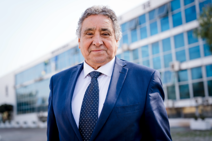 La imagen muestra al profesor Juan Ivanovic de pie frente a la casa central de la universidad