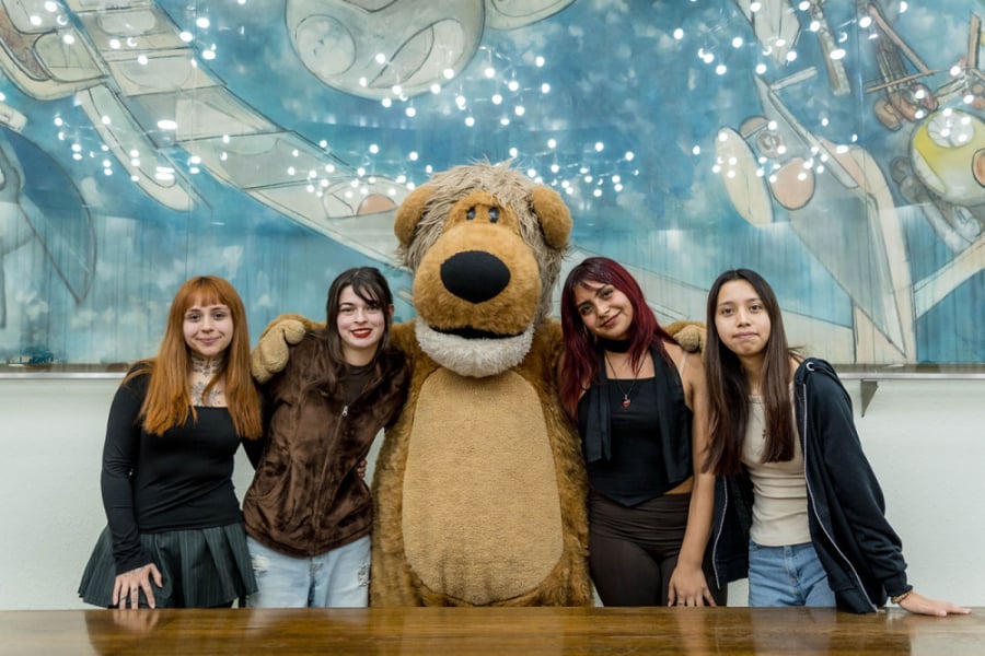 La imagen muestra a las estudiantes del proyecto posando junto a usachin en el Salón de Honor de la Universidad