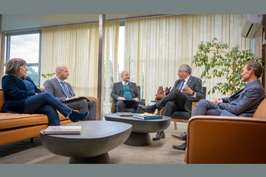 La imagen muestra a las autoridades reunidas sentadas conversando en la oficina del rector
