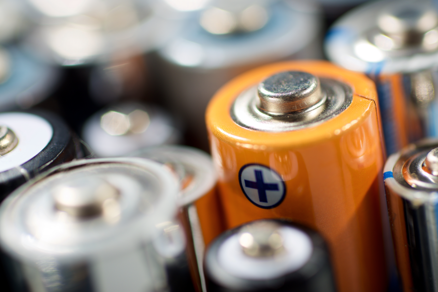 Extreme close-up of grouped cylindrical batteries highlighting positive terminal icons.