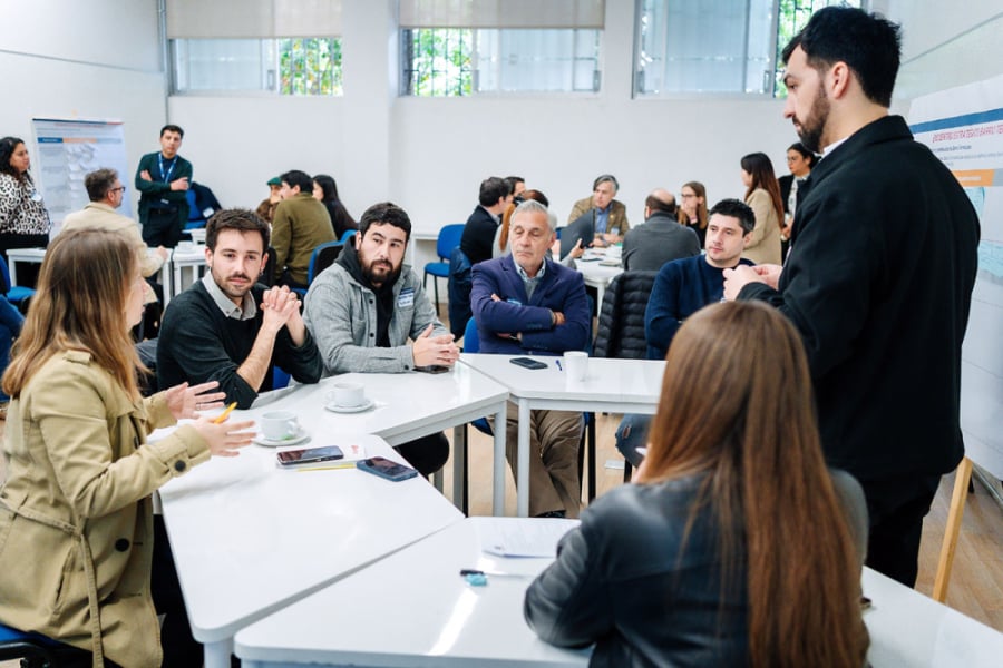 En la imagen aparece representantes de diversas comunidades que participaron de la actividad. Están sentados alrededor de una mesa y discuten sobre el tema