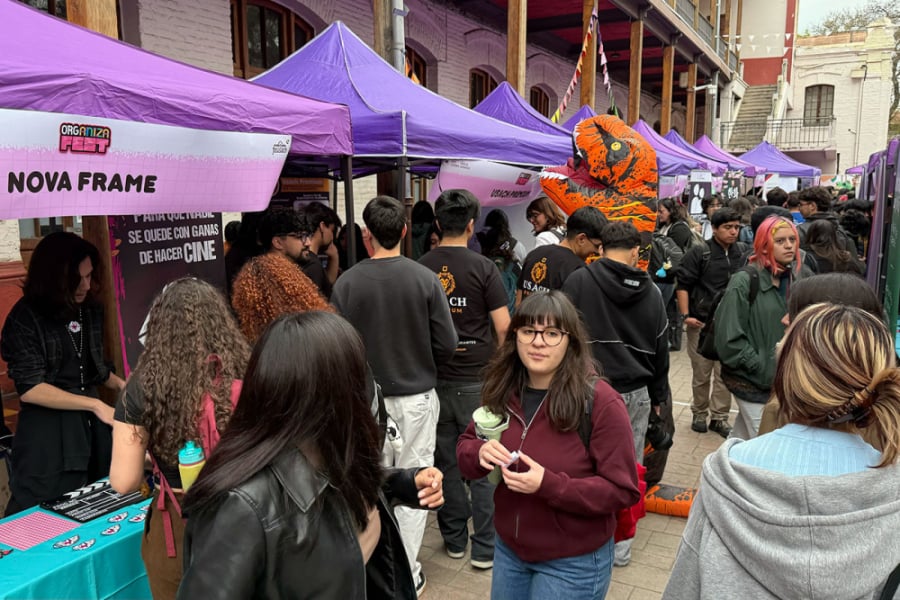 En la imagen se puede apreciar al estudiantado Usach siendo parte de la feria, participando de los stand que se caracterizan por toldos morados y azules