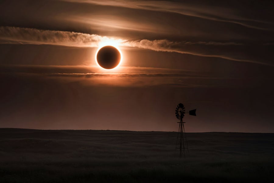 Un eclipse solar total oscurece el cielo sobre un molino de viento.