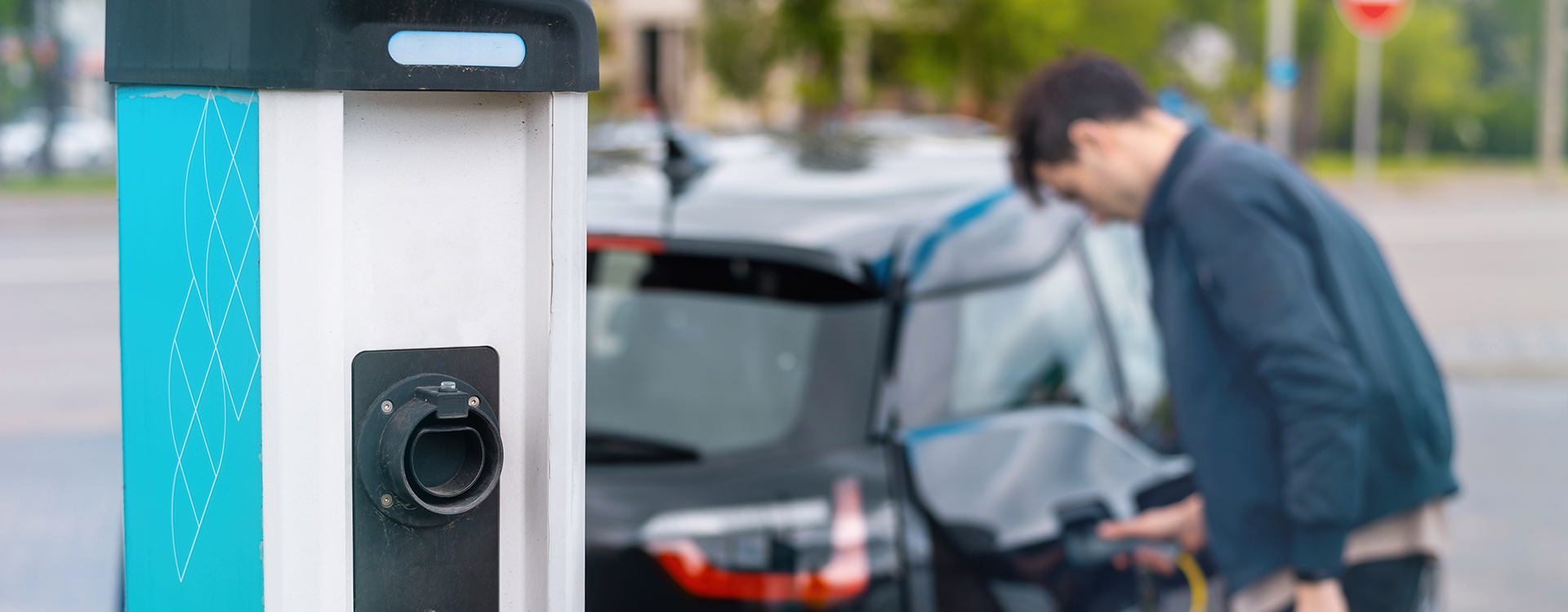 Persona cargando auto eléctrico.